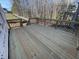 Newly constructed wooden deck featuring railings and stairs with a view of the wooded backyard at 113 Arundel Dr, Archer Lodge, NC 27527