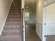 Inviting foyer with carpeted stairs and wood flooring, showcasing the home's transition to living spaces at 113 Arundel Dr, Archer Lodge, NC 27527