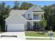 Charming two-story home with a manicured lawn, attached garage, stone accents, and covered porch at 113 Arundel Dr, Archer Lodge, NC 27527