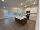 Bright kitchen boasts a large island, stainless appliances, white cabinets, and hardwood floors at 113 Arundel Dr, Archer Lodge, NC 27527