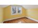 Attic bedroom featuring wood floors, yellow walls, and bright windows at 1146 Rogers Rd, Graham, NC 27253