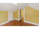 Attic bedroom features wood floors, yellow walls, and access to attic storage at 1146 Rogers Rd, Graham, NC 27253