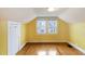 Attic bedroom features wood floors, yellow walls, and bright windows at 1146 Rogers Rd, Graham, NC 27253