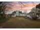 Spacious backyard with mature trees and a partially fenced perimeter for added privacy at 1146 Rogers Rd, Graham, NC 27253