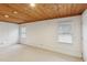 Finished basement with carpet, wood ceiling, and two windows for natural light at 1146 Rogers Rd, Graham, NC 27253