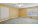 Bright bedroom with neutral carpet, yellow walls, ceiling fan, and a window with shutter-style blinds at 1146 Rogers Rd, Graham, NC 27253