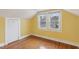 The bedroom features hardwood floors, bright yellow walls, and natural light from a window at 1146 Rogers Rd, Graham, NC 27253