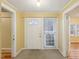 Bright entryway featuring a white front door, neutral carpet, and yellow walls at 1146 Rogers Rd, Graham, NC 27253