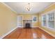 Bright living room featuring hardwood floors, a decorative fireplace, built-in shelving, and large windows at 1146 Rogers Rd, Graham, NC 27253