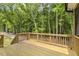 A wooden back deck surrounded by trees and a lawn at 115 Arundel Dr, Archer Lodge, NC 27527