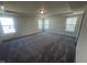 Spacious bedroom features neutral carpet, tray ceiling, and three windows providing ample natural light at 115 Arundel Dr, Archer Lodge, NC 27527
