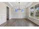 A bright dining room with hardwood floors, a chandelier, large windows, and decorative molding at 115 Arundel Dr, Archer Lodge, NC 27527