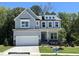 Beautiful two-story home featuring gray siding, stone accents, a two-car garage, and well-manicured front yard at 115 Arundel Dr, Archer Lodge, NC 27527