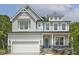 Beautiful two-story home with a light gray exterior, a covered front porch and an attached two-car garage at 115 Arundel Dr, Archer Lodge, NC 27527