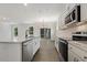 A modern kitchen with white cabinets, stainless steel appliances, and an island with a sink at 115 Arundel Dr, Archer Lodge, NC 27527