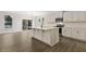 Bright open kitchen features a large island, white cabinets, modern appliances, and wood floors at 115 Arundel Dr, Archer Lodge, NC 27527