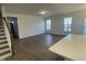 Open-concept living room with hardwood floors, large windows, and plenty of natural light at 115 Arundel Dr, Archer Lodge, NC 27527