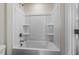 A white shower tub combo with built-in shelving at 115 Arundel Dr, Archer Lodge, NC 27527