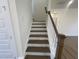 View of wood stairs with white risers and banister leading to the next level at 115 Arundel Dr, Archer Lodge, NC 27527