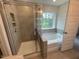 Modern bathroom featuring a tiled shower and separate soaking tub by a window at 116 Arundel Dr, Archer Lodge, NC 27527