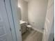 Clean powder room featuring a vanity, toilet, and gray hardwood flooring at 116 Arundel Dr, Archer Lodge, NC 27527