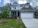 Beautiful two-story home featuring a stone facade, a two-car garage, landscaped yard, and a covered front porch at 116 Arundel Dr, Archer Lodge, NC 27527