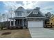 Two-story home featuring a stone and siding exterior, two-car garage, and a well-manicured lawn at 116 Arundel Dr, Archer Lodge, NC 27527