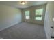 Carpeted bedroom with two windows overlooking the neighborhood at 118 Arundel Dr, Archer Lodge, NC 27527