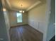 Bright dining room with gray vinyl floors, white trim and chair rail, and a modern light fixture at 118 Arundel Dr, Archer Lodge, NC 27527