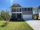 Charming two-story home featuring a double porch, neutral siding, well-kept lawn, and attached two car garage at 118 Arundel Dr, Archer Lodge, NC 27527