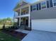 Two-story home featuring a double porch, neutral siding, well-kept lawn, and attached two car garage at 118 Arundel Dr, Archer Lodge, NC 27527