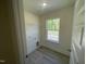 Well lit laundry room with wood flooring, a window and shelving installed at 118 Arundel Dr, Archer Lodge, NC 27527