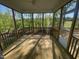 View of a screened porch with a ceiling fan and a view of the wooded backyard at 118 Arundel Dr, Archer Lodge, NC 27527