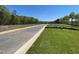 View of a freshly paved neighborhood street with landscaped lawns and mature trees at 118 Arundel Dr, Archer Lodge, NC 27527