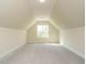 Bright attic room featuring a large window and neutral color palette at 1233 Azalea Garden Cir, Raleigh, NC 27603