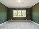 Green bedroom showcases a large window and neutral carpet at 1233 Azalea Garden Cir, Raleigh, NC 27603