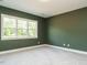 Bedroom with green walls, carpet, and view from the window at 1233 Azalea Garden Cir, Raleigh, NC 27603