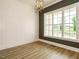 Dining room with wood floors, modern light fixture, white wainscoting and a large window at 1233 Azalea Garden Cir, Raleigh, NC 27603