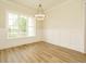 Dining room with wood floors, wainscoting, crown molding, modern light fixture, and large window at 1233 Azalea Garden Cir, Raleigh, NC 27603