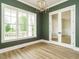 Dining room with wood floors, modern light fixture, white trim, and double glass doors at 1233 Azalea Garden Cir, Raleigh, NC 27603