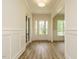 Bright foyer with hardwood floors, white trim, paneled walls, and a glass-paneled front door at 1233 Azalea Garden Cir, Raleigh, NC 27603