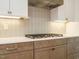 Close up view of a gas range and decorative tile backsplash at 1233 Azalea Garden Cir, Raleigh, NC 27603