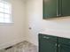 Functional laundry room with green cabinets, sleek countertop, and hexagon tile floors at 1233 Azalea Garden Cir, Raleigh, NC 27603