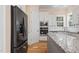 Sleek black refrigerator and granite island in a bright, updated kitchen at 1360 Cedar Grove Rd, Pittsboro, NC 27312