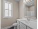 Elegant bathroom with white vanity, framed mirror, and ample natural light at 5093 Nc 56 Hwy, Franklinton, NC 27525