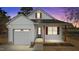 Charming white home with a gray door, wooden pillars and shutters against a colorful sunset sky at 5093 Nc 56 Hwy, Franklinton, NC 27525