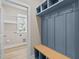 Well-organized mudroom with custom blue storage lockers and a bench, adjacent to the laundry room at 5093 Nc 56 Hwy, Franklinton, NC 27525