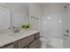 Bright bathroom featuring a single vanity, quartz countertop, and a combined shower and tub at 55 Diamond Creek Dr, Zebulon, NC 27597