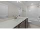 Bright bathroom featuring a shower-tub, gray vanity, and speckled white countertop at 55 Diamond Creek Dr, Zebulon, NC 27597
