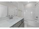Bright bathroom featuring a shower-tub, gray vanity, and speckled white countertop at 55 Diamond Creek Dr, Zebulon, NC 27597